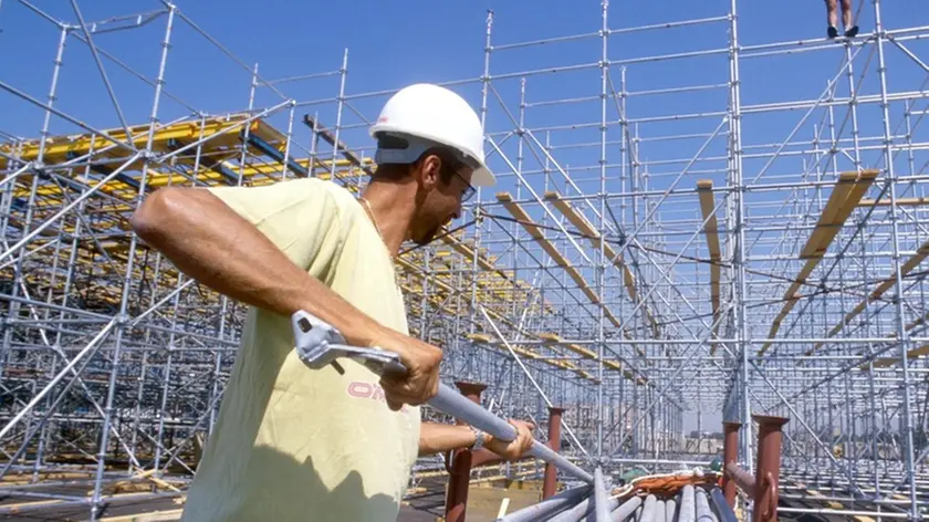 LAVORI EDILI, CANTIERE OPERAIO CON CASCHETTO