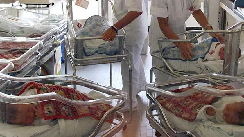 Due infermiere con alcuni neonati in ospedale in una foto d'ARCHIVIO. ANSA - Neonati nella nursery di un ospedale di Roma