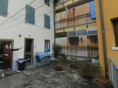 La signora Roberta De Bastiani indica i muri del condominio dell’Ater costruiti 20 anni fa a ridosso della sua casa in barba alle regole sui confini