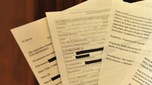 20090804- CLJ -TORINO- TRUFFE: PROMETTEVA A STRANIERI PERMESSI DI SOGGIORNO MAI AVUTI - Un poliziotto mostra i falsi permessi di soggiorno sequestrati ad una torinese di 32 anni, amministratrice di alcune cooperative, e' stata arrestata per truffa dagli agenti del commissariato Dora Vanchiglia, oggi 4 agosto 2009 a Torino. /ANSA/Tonino Di Marco / DBA