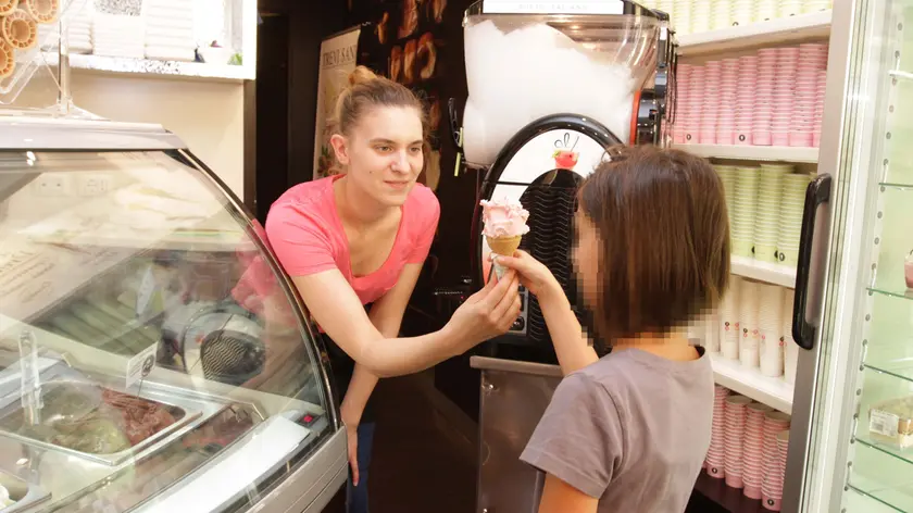 Una gelatiera offre un gelato a una bimba