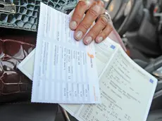 Un bollo e un libretto di circolazione di un'automobile di lusso, fotografati oggi 16 luglio 2011 a Pisa. La manovra economica approvata in tempi ultrarapidi dal Parlamento e' stata pubblica oggi in Gazzetta Ufficiale. Entrano cosi' in vigore da domani le norme modificate non previste dal decreto originario. Da subito scattano i rincari del bollo sul deposito titoli, il superbollo per le auto di lusso sopra i 225 kw, la stretta sulle stock option, l'aumento dell'Irap sulle concessionarie dello Stato e la normativa che potrebbe portare all'applicazione di ticket sanitari. Per altre norme la concreta attuazione segue un diverso calendario: dal prelievo sulle pensioni d'oro, che parte dal primo agosto, al taqlio sulle agevolazioni fiscali che si applichera' dal 2013.ANSA/FRANCO SILVI