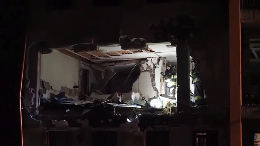 I vigili del fuoco mentre ispezionano l'appartamento al primo piano in via Rio a Feltre devastato dall'esplosione