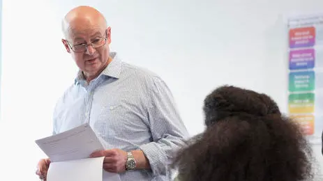 Professor giving exam results to university students