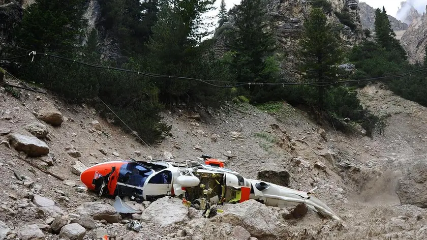 20090822 - CORTINA D'AMPEZZO - BELLUNO - DIS - PRECIPITA UN ELICOTTERO DEL 118: QUATTRO MORTI NEL BELLUNESE. L'elicottero del Suem precipitato questo pomeriggio 22 agosto 2009. La procura ..della Repubblica di Belluno ha aperto un fascicolo d'inchiesta sulla caduta dell'elicottero del Suem di Pieve di Cadore che ha provocato la morte delle quattro persone a bordo. L'elicottero stava intervenendo per una verifica nella zona di Rio Gere, tra il monte Cristallo e il Faloria, dove si era staccata una frana che aveva invaso un tratto stradale. Durante una manovra, sul versante del Cristallo, eseguita forse in seguito anche al maltempo, il velivolo avrebbe toccato i fili della tensione ed e' quindi precipitato...ANSA/EMILIO ZANGIACOMI POMPANIN/DRN I resti dell'elicottero dopo lo schianto al suolo