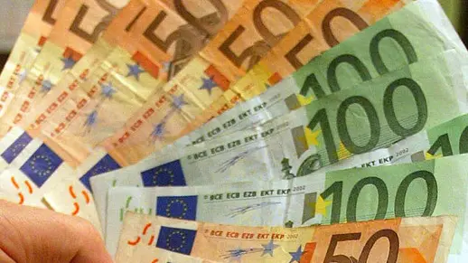 Un uomo tiene in mano alcune banconote di Euro, in una immagine di archivio. ANSA/ETTORE FERRARI/DRN