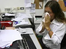 Una donna si soffia il naso in un'immagine d'archivio. Si diffondono "a macchia d'olio" le malattie allergiche in Italia, respiratorie ed alimentari, che colpiscono attualmente il 30-35% degli italiani. Dai pollini agli epiteli di cane e gatto, dagli acari della polvere alle muffe, le allergie sono un problema crescente ed entro il 2015 potrebbero colpire fino al 45% della popolazione in Italia. ANSA / FRANCO SILVI