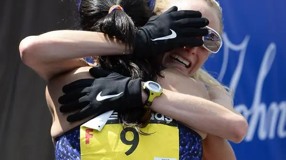 epa03663243 Shalane Flannagan of the United States (R) is embraced by teammate Kara Goucher (L) after they crossed the finish line in fourth and sixth place respectively in the Women's Division of the 117th Boston Marathon in Boston, Massachusetts, USA 15 April 2013. EPA/CJ GUNTHER