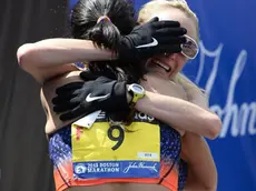 epa03663243 Shalane Flannagan of the United States (R) is embraced by teammate Kara Goucher (L) after they crossed the finish line in fourth and sixth place respectively in the Women's Division of the 117th Boston Marathon in Boston, Massachusetts, USA 15 April 2013. EPA/CJ GUNTHER