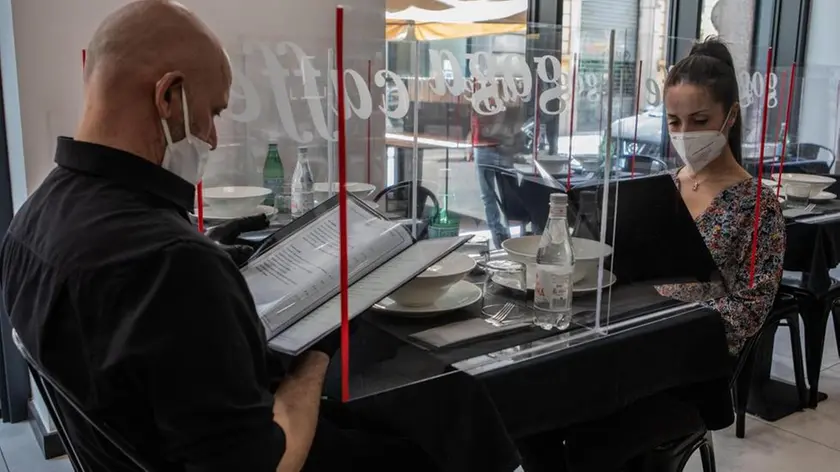 05/05/2020 Milano, Fase 2: ristorante si prepara ad accogliere i clienti con lastre di plexiglass per dividere i tavoli; nella foto due dipendenti dimostrano l’utilizzo