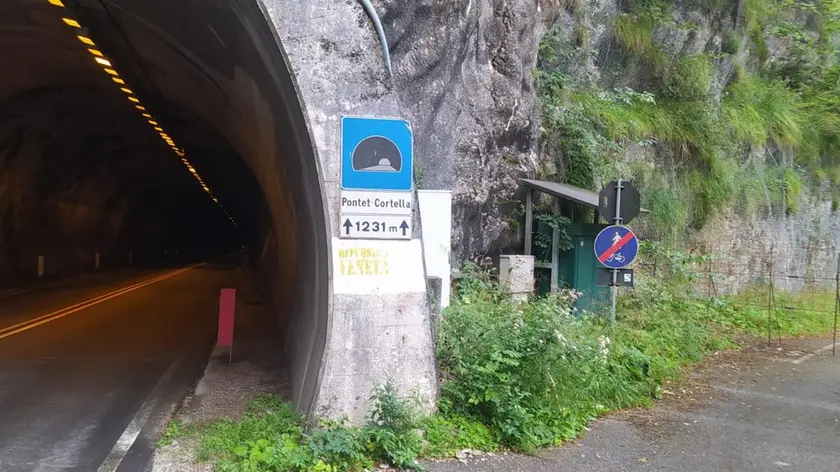 L’imbocco della galleria Pontet - Cortella sulla Sr 50 con a destra l’ingresso della ciclabile, sbarrato da una rete metallica