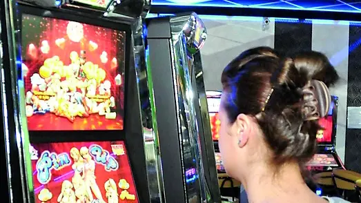 Una giocatrice davanti alle slot machine