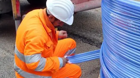 Un tecnico impegnato nella posa di una conduttura in fibra ottica