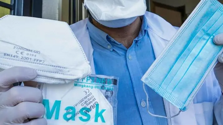 Un farmacista mostra una confezione di mascherine Il cui prezzo è esposto alla porta vetrata. di Torino, 9 aprile 2020 ANSA/TINO ROMANO