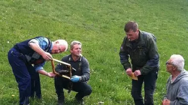 Gli esperti osservano i danni causati dall’orso e in alto l’alveare distrutto sul prato dell’abitazione