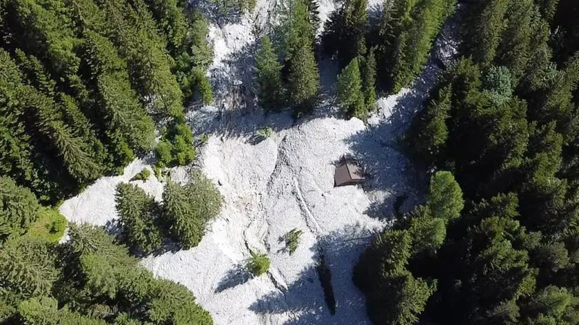 Una delle baite sommerse e la devastazione portata dalla frana nell’immagine ripresa dal drone