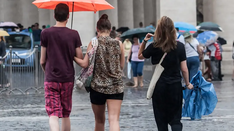 10/08/2015 Roma. Maltempo sulla Capitale. Nella foto Alcuni turisti con delle mantelline in Piazza San Pietro