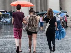 10/08/2015 Roma. Maltempo sulla Capitale. Nella foto Alcuni turisti con delle mantelline in Piazza San Pietro