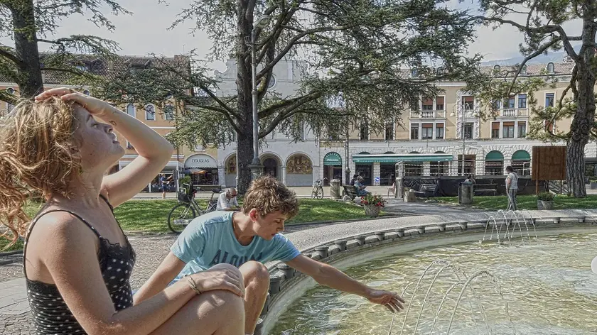 Caldo fino a mercoledì: a Belluno due giovani si bagnano nella fontana di piazza dei Martiri