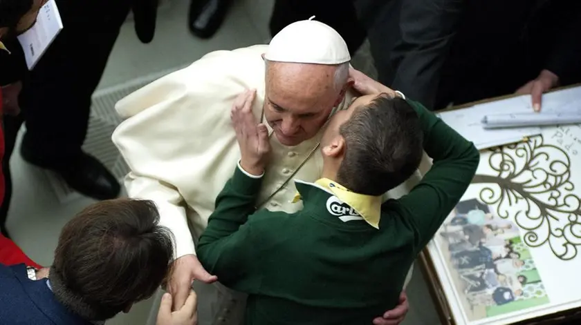 22/11/2014 Citta' del Vaticano, udienza del papa alle famiglie, alle associazioni e agli enti di cura delle persone con autismo. Nella foto papa Francesco riceve il saluto di un ragazzo autistico