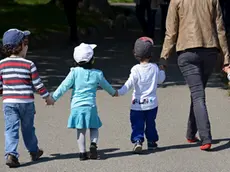 young woman walking hand in hand with four children, Perle du Lac Parc on the shore of Geneva Lake, Geneva, Switzerland