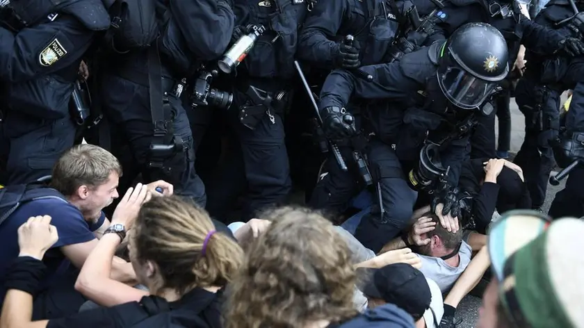 epa06076463 Riot police scuffle with protesters a protests against the G20 summit in Hamburg, Germany, 08 July 2017. The G20 Summit (or G-20 or Group of Twenty) is an international forum for governments from 20 major economies. The summit is taking place in Hamburg 07 to 08 July 2017. EPA/FILIP SINGER