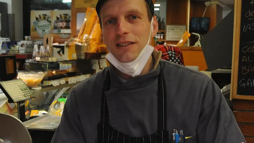 Giuseppe Scarton dietro il bancone del negozio di alimentari di Visome