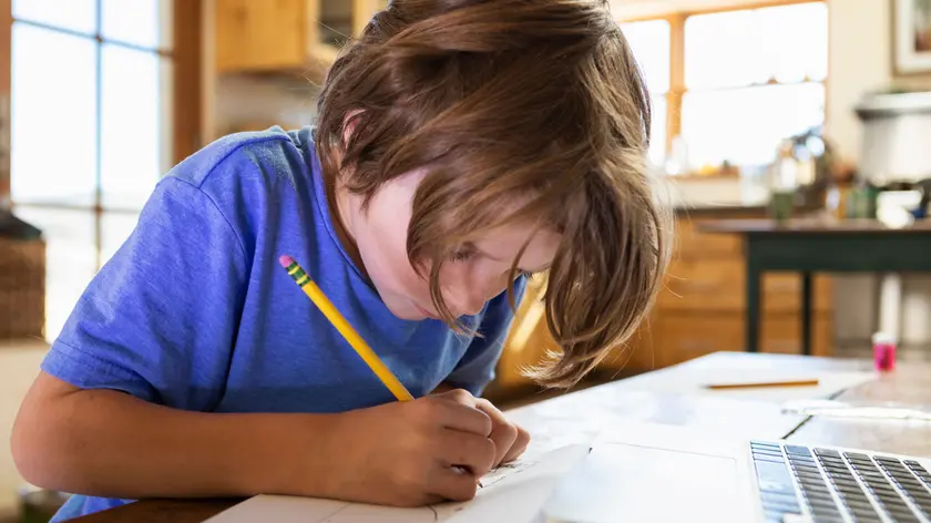 Un ragazzo impegnato nei compiti scolastici