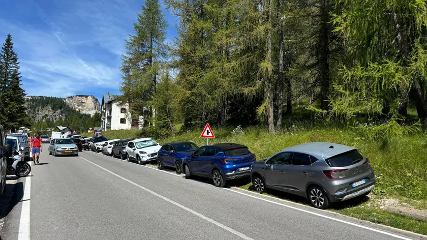 Auto parcheggiate a bordo strada sul passo Tre Croci a Cortina
