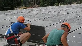 Lavoratori su un tetto installano pannelli fotovoltaici