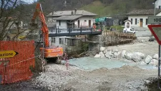 Al centro il ponte bailey con gli operai al lavoro A destra una casa