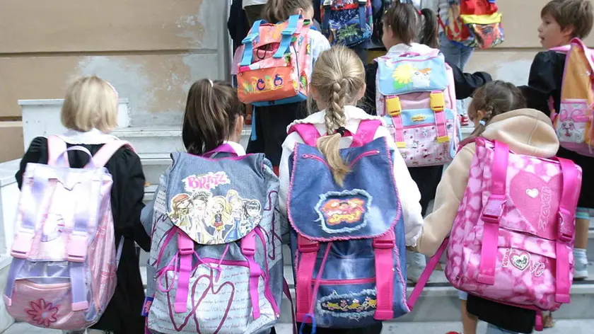 GENOVA 20030915 20030915 - GENOVA - CRO - SCUOLA: VACANZE FINITE - Un gruppo di scolari entra a scuola per il primo giorno di lezione, oggi a Genova. Torna a suonare la campanella per gli studenti italiani, il rientro in classe riguardera', tranne poche eccezioni, l'intera categoria. LUCA ZENNARO/ANSA/TO (LUCA ZENNARO/ ) Primo giorno di scuola in una scuola elementare Alunni delle elementari. Per loro novita' in vista Alunni delle elementari al rientro a scuola