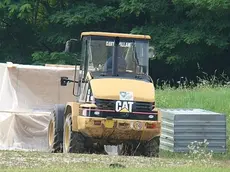 A sinistra una catasta di pannelli di legno pronti per essere usati per recintare l’area dell’Altanon. A destra una veduta dall’alto della recinzione vicino alla Coop