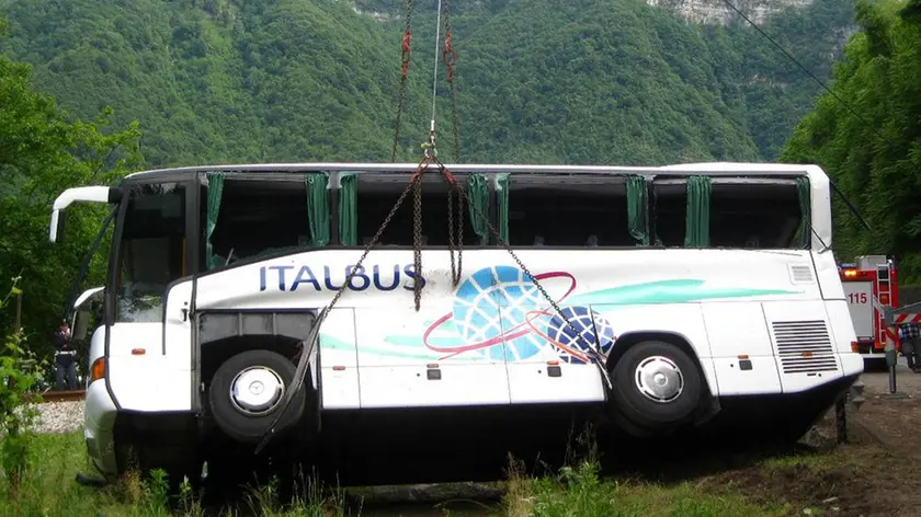 Vigili del fuoco impegnati nelle operazioni di recupero del pullman che si è ribaltato a Carpen, una frazione di Feltre, 29 maggio 2014. Sarebbero alcune decine i bambini rimasti feriti nell'incidente, due di loro e un accompagnatore sono gravi. ANSA/ANDREA SOLERO