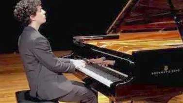 Giacomo Menegardi durante una esibizione al pianoforte a coda
