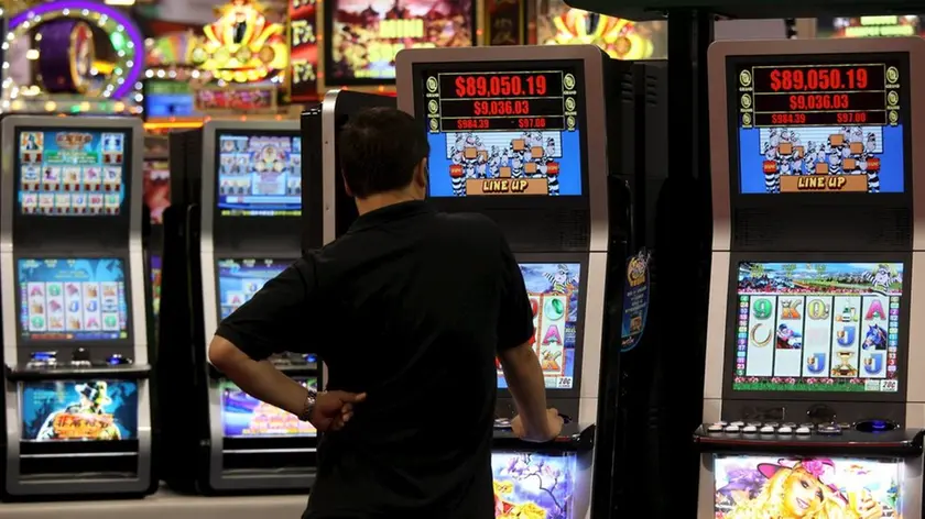 Un uomo gioca con una slot machine in una foto d'archivio. ANSA / YM YIK .