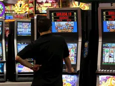 Un uomo gioca con una slot machine in una foto d'archivio. ANSA / YM YIK .