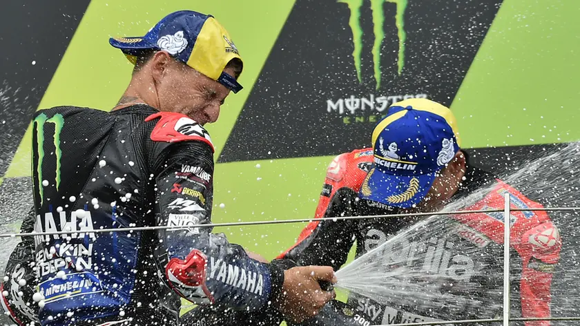 MotoGP race winner France's rider Fabio Quartararo of the Monster Energy Yamaha MotoGP, left, celebrates on the podium with third placed Spain's rider Aleix Espargaro of the Aprilia Racing Team Gresini after the MotoGP race at the British Motorcycle Grand Prix at the Silverstone racetrack, in Silverstone, England, Sunday, Aug. 29, 2021. (AP Photo/Rui Vieira)