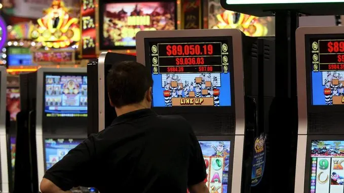 Un uomo gioca con una slot machine in una foto d'archivio. ANSA / YM YIK .