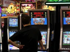 Un uomo gioca con una slot machine in una foto d'archivio. ANSA / YM YIK .