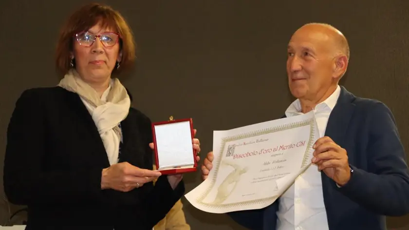 Cinzia Lusa consegna il riconoscimento ad Aldo Pellencin