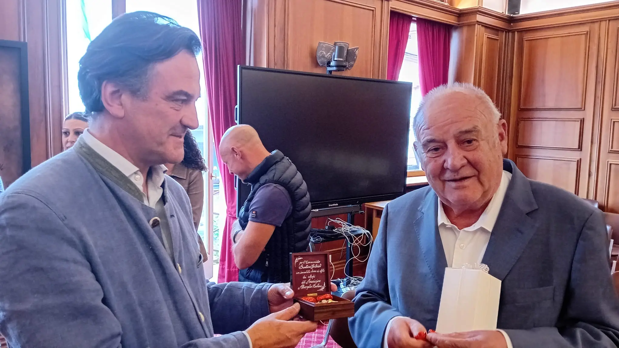 Gherardo Manaigo consegna il riconoscimento dell'Associazione albergatori di Cortina a Santino Galbiati