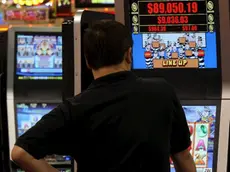 Un uomo gioca con una slot machine in una foto d'archivio. ANSA / YM YIK .